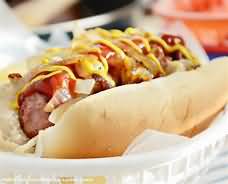 Frankfurter with bun, ketchup, fried onions and mustard