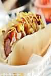 Frankfurter with bun, ketchup, fried onions and mustard